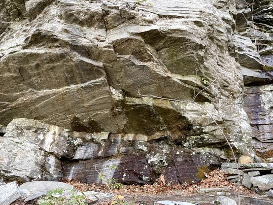 Not far from the bog is this large rock formation, a good 18 feet high. The stone looks like it has been chiseled away is large slabs that almost look cave-like and jut over the little trail that passes under.
