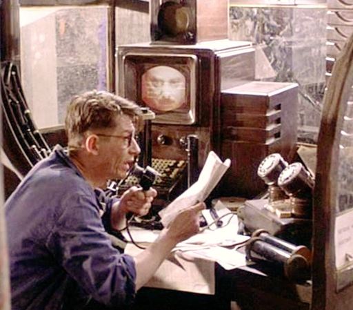In a scene from a film adaption of 1984, John Heard as Winston Smith edits the news at the Ministry of Truth.
