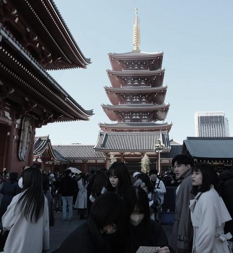 The courtyard in front of the Senso-ji Temple pagoda. People walking by form a nearly symmetric pattern.