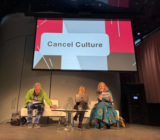 Die drei genannten Personen auf der Bühne, dahinter ist auf einer Videoleinwand "Cancel Culture" zu lesen. Evelyn Schalk hat das Mikrophon.