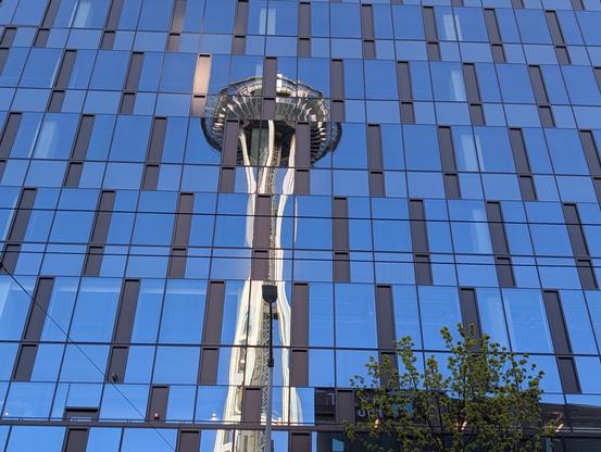 The Space Needle reflected on a building's windows.