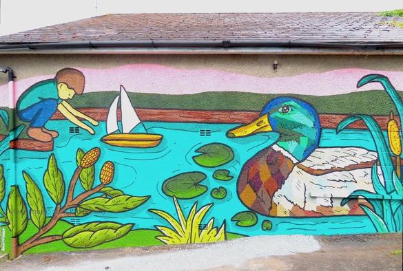 wall-painting showing the scene around a pond: a child launches a toy boat (top left); a duck swims (right); a branch, lily-pads, and rushes complete the scene