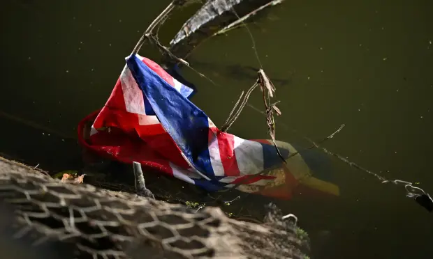 A union jack floats under the A12 bypass, downstream of a polluted tributary of the River Deben, near a storm overflow at Wickham Market, eastern England in December 2024