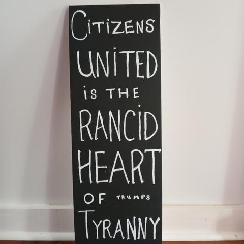 black handmade sign, white lettering: 
CITIZENS UNITED
is the
RANCID
HEART
of Trump's
TYRANNY