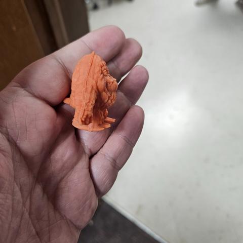 a small chungus of a sasquatch toy in orange rubbery plastic from the side view - he's thick!