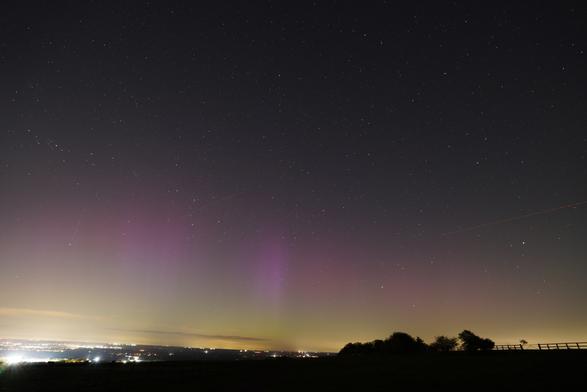 An auroral display from North Oxfordshire on the night of April 16th 2025. Pink pillars of light dance above a green glow across the northern horizon.