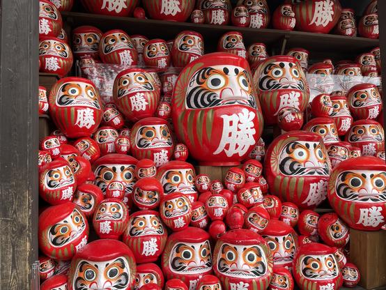 Daruma (Bodhidharma) dolls all over the temple, with the theme of winning or victory (勝) in the temple's name