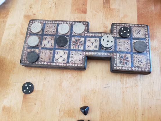 A table with a Game of Ur board with a game partially complete.
