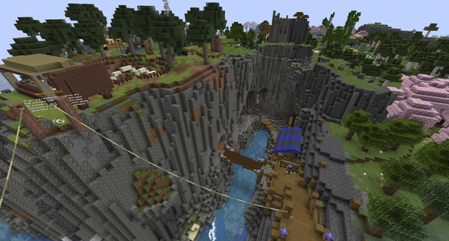 Minecraft screenshot. An ocean ravine dividing a wooden inclined pathway and a shed with a fenced area. Green hanging wires connect the areas, and many trees and buildings are seen in the distance.