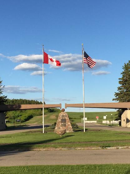 A Canadian flag and an American flag side by side along the Manitoba/North Dakota border.