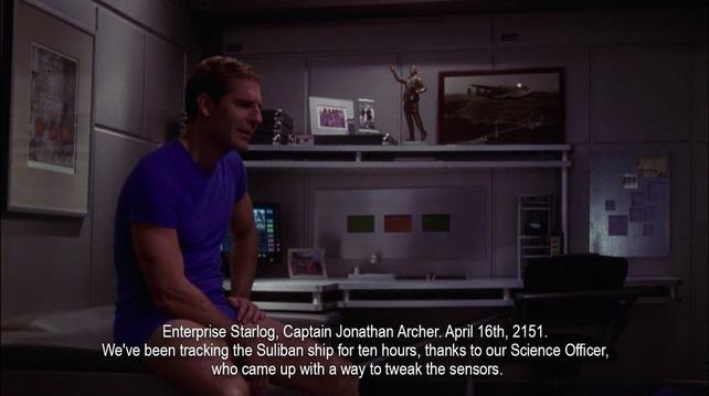 A fit man in his underclothes sits in a small, tidy spaceship room. He's speaking out loud to an invisible recording system, saying, “Enterprise Starlog, Captain Jonathan Archer. April 16th, 2151. We've been tracking the Suliban ship for ten hours, thanks to our Science Officer, who came up with a way to tweak the sensors.”