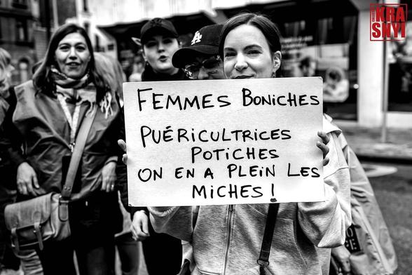 Une pancarte "FEMMES BONICHES, PUÉRICULTRICES POTICHES, ON EN A PLEIN LES MICHES !"