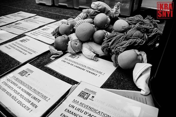 Des poupées bébé couchées sur des affichettes avec les revendications des manifestantes.