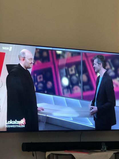 Foto aus dem Studio der WDR-Lokalzeit mit P. Maurus und dem Moderator