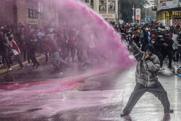 Un manifestant aixeca el puny mentre els agents utilitzen un canó d'aigua per dispersar la concentració (World Press Photo)