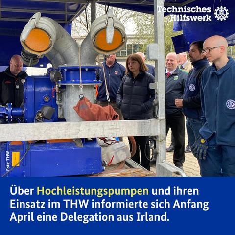 Mehrere Menschen stehen um eine große Pumpe herum.