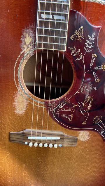 A different brand new Gibson acoustic guitar with horrible “aging”, which means the lacquer has been pointlessly scraped off around the sound hole.
