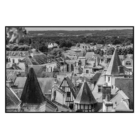 (English follows) Photographie noir et blanc, format paysage, ratio 3x2. La photographie saisit les toits de la cité médiévale de Chinon : toits pentus, colombages... au loin, la campagne tourangelle. 

Black and white photograph, landscape format, 3x2 ratio. The photograph captures the roofs of the medieval city of Chinon: sloping roofs, half-timbering... in the distance, the Touraine countryside.