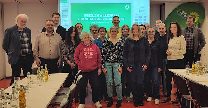 Eine Gruppe von Menschen gemischten Alters und Geschlecht steht in einem Besprechungssaal vor den Enden der Tische. Im Hintergund ist eine Präsentation der Grünen zu sehen. Auf dem Bild sind zu sehen v.l.n.r.: Volker Brand, Joachim Carstensen, Jan Schormann, Regine Brand, Tobias Wolf, Beate Carstensen, Petra Henning, Gabriele Freimuth, Erika Külbel-Schmidt, Thomas Dippert, Barbara Lamp, Alexandra Edler, Christian Fitte, Thomas Schmidt, Ingrid Schley, Norbert Heinrich, Ludger Mogge, Beate Baron, Andreas Edler