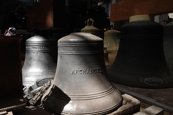 Various bells stored on the workshop floor.  The one in the foreground is named 'Archangel'.
