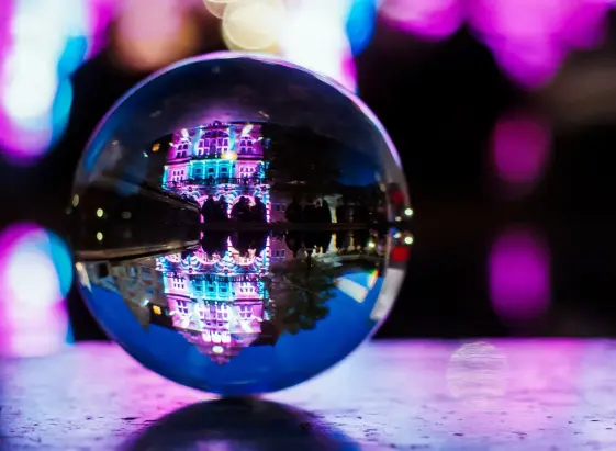 Eine Glaskugel zeigt das bunt beleuchtete Bielefelder Rathaus. Quelle: bielefeld.jetzt