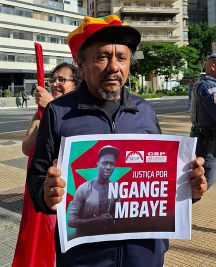 Chico César em manifestação segurando cartaz com "Justiça para Ngange Mbaye"