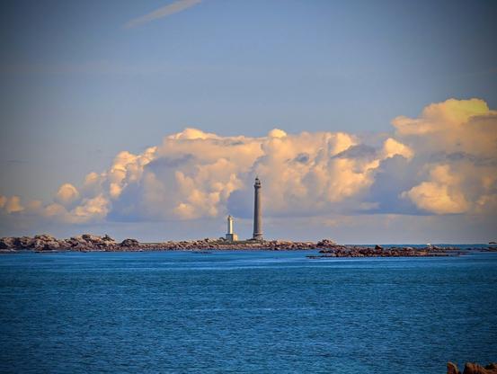 Vue lointaine de l'île Vierge et des deux phares, un petit et le grand de 82 mètres de haut.
