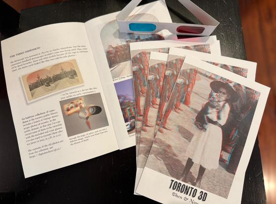 copies of my new zine, stacked upon a copy that is open to the first two pages. zine cover shows a vintage 3d red/cyan photo of a girl holding a dog. title reads "toronto 3D: then & now"