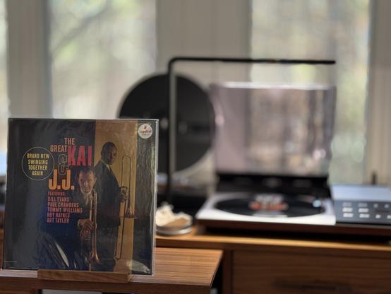 Kai Winding & J.J. Johnson  = The Great Kai & J.J. LP cover.

Kai and JJ holding their trombones on a mostly black background, with titles over black to the left.

The black LP plays on a vintage, restored Bang & Olufsen Beogram 8002 linear-tracking turntable to the right.