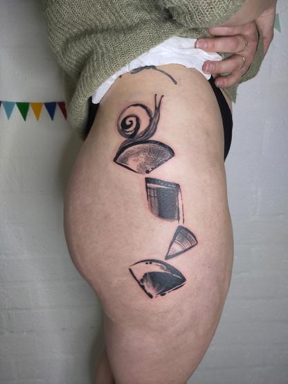 Tattoo of a composition of shaped with a snail om top