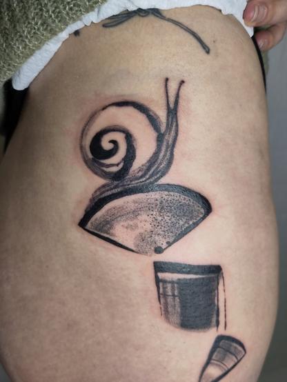 Tattoo of a composition of shaped with a snail om top