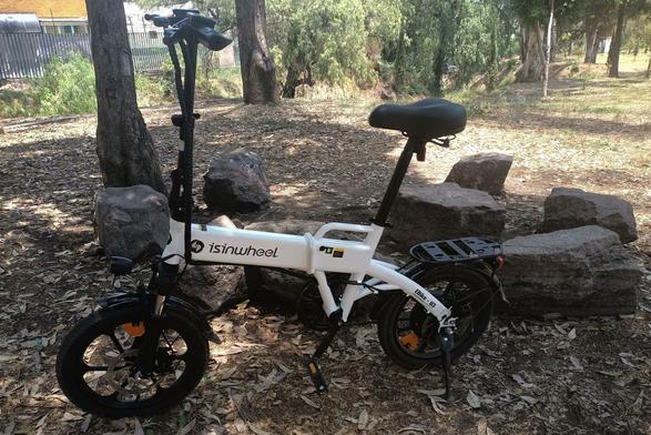 my black and white ebike parked in front of some set os stones over the dirt road.