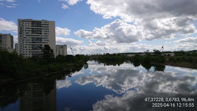 Le Cher à Joué-les-Tours, entre immeubles HLM, végétation et ciel se reflétant dans la large rivière