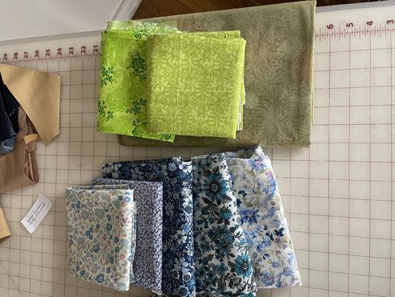 Another spread of floral print cotton fabrics in cool shades of green and blue.