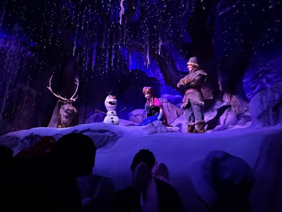 Scene from Frozen attraction. audio-animatronic figures of Sven, Olaf, Anna, and Kristoff are in a snowy scene.