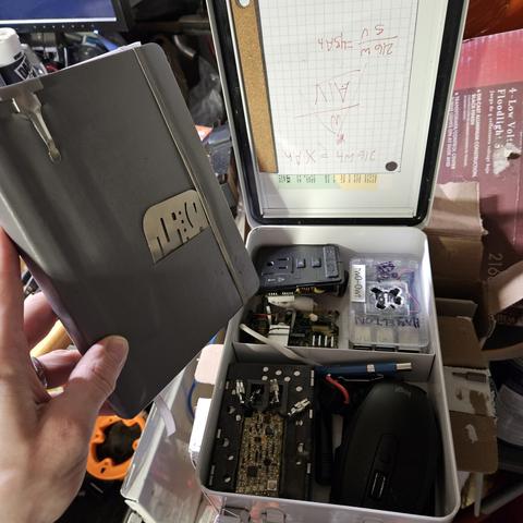 a punk box px with a raspberry pi, barrery, inverter, small mouse, notebook up revealing all.