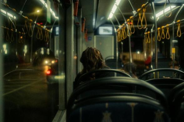 person sitting in empty night bus