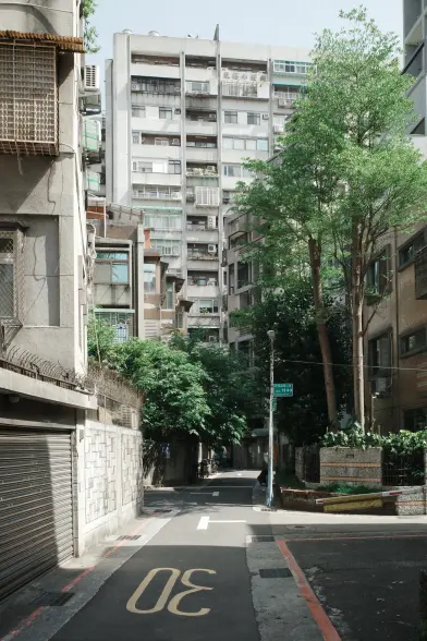 A street scene in central Taipei: residential buildings, and apartment blocks, some trees line a street