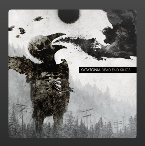 The album cover for Dead End Kings by Katatonia features a haunting, surreal collage in muted monochrome tones. In the foreground, a skeletal, bird-like humanoid figure stretches its arm outward, its form rough and eroded. A black sun looms overhead, partially obscured by swirling ink-like clouds. Several birds are flying off into the distance. Below, a misty forest filled with bare trees and telephone poles stretches into the background, creating an atmosphere of desolation and decay. The band's name "Katatonia" and the album title "Dead End Kings" are displayed in stark black and white text to the right.