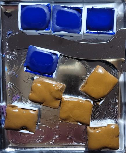 Foto eines Blechkastens mit 9 Aquarellnäpfchen, 4 blaue und 5 hellbraune