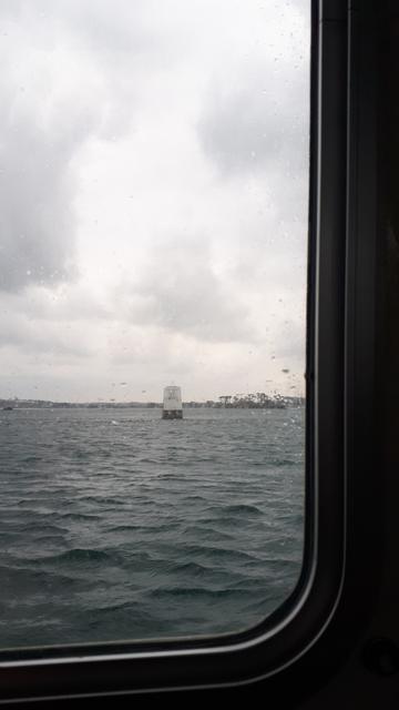 Vue sur la mer par temps gris, à travers le hublot d'une navette entre le port de Roscoff et l'île de Batz