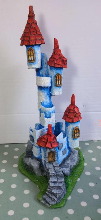 A towering model castle with white walls and red roofs.