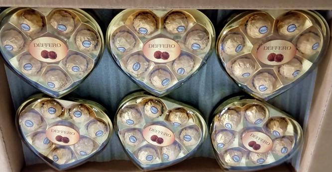 A customs photo of six packs of Deffero. The packs are heart shaped and contain 7 or 8 gold foil wrapped balls with stickers on them. A picture shows two chocolate balls. The photo has been rotated to make the text readable.
