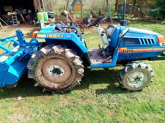 Before: A nice blue tractor with rototiller attached. The big rear wheel is covered in mud all the way to the hub, front wheels not much better, the driver floor is crusted in slabs of mud.