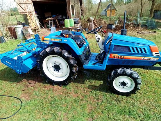 After washing: The same tractor, now all shiny and clean and glistening in the sun. The white rims are white again and the rubber floor mat is removed from the driver area and drying somewhere else.