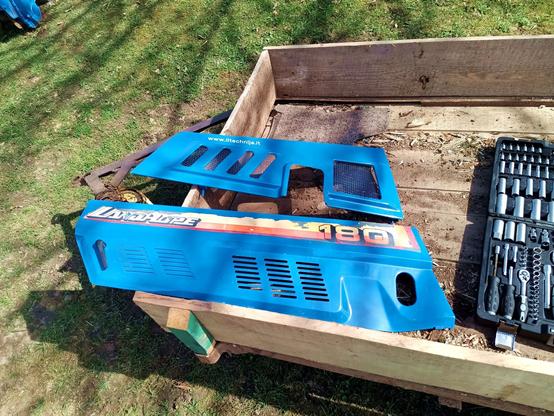 The removable blue access panels resting in a trailer along with a toolkit.