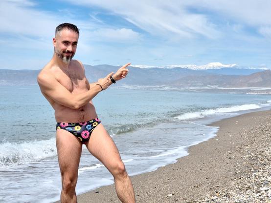Fotografía posando en la orilla del mar, señalando Sierra Nevada cubierta de nieve haciendo honor a su nombre