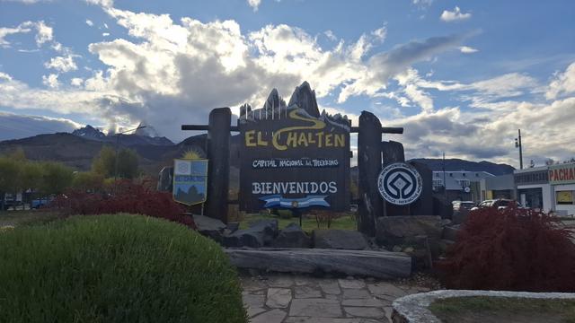 Blauer Himmel und ein paar Wolken vor dem Willkommensschild von El Chalten
