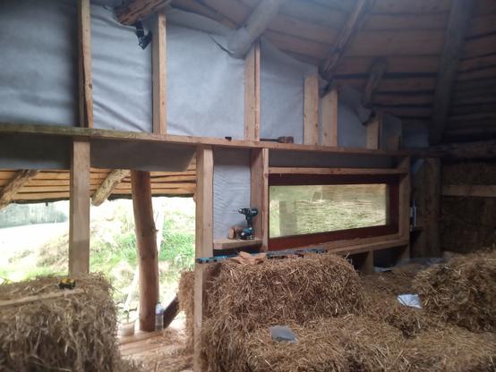 First window roughly in place. The inside of the house is still littered with left over straw bales.