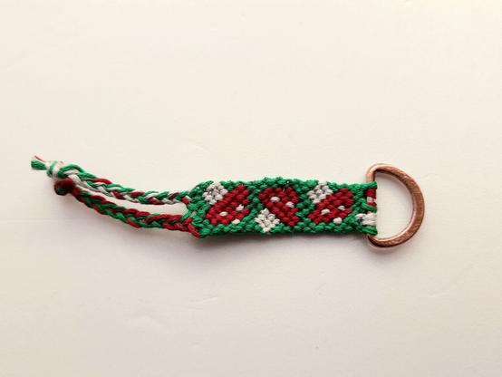 Ein Schlüsselanhänger mit dreii Glückspilzen. Geknüpft.